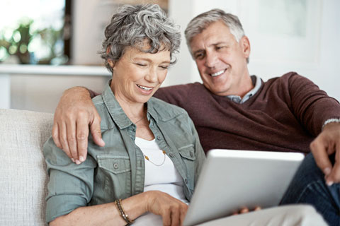 A happy couple is using the Affinity Patient Portal on a desktop computer