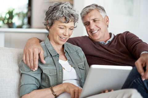 A happy couple is using the Affinity Patient Portal on a desktop computer