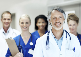 A doctor and their staff standing in a group and smiling